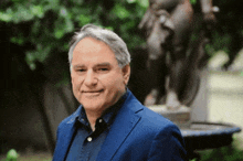 a man in a blue suit is standing in front of a fountain