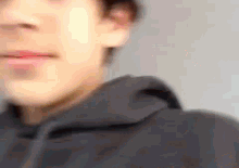 a close up of a man 's face with a hoodie on