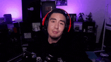 a man wearing headphones and a microphone is giving a thumbs up