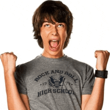 a young man wearing a gray rock and roll high school shirt