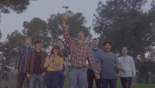 a group of people are standing around a man holding a hammer