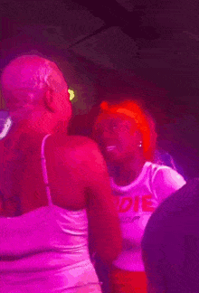 a blurry picture of people dancing in a dark room with pink lights