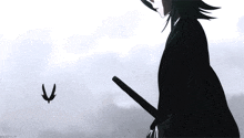 a person is holding a sword and a bird is flying in the sky .