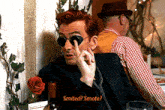a man with red hair and sunglasses says " smited "