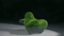 a green object is sitting on top of a white surface .