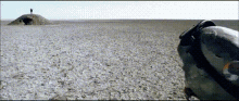a person standing on top of a small hill in the middle of a desert