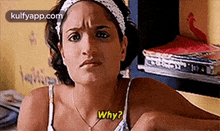 a woman is sitting on a bed and making a funny face and asking why .
