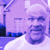 a bald man with a beard is smiling in front of a house