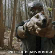 a man is pointing a gun at the camera with the words spill the beans bitchflix written below him .