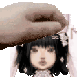 a hand is touching a doll 's head with a flower in her hair .