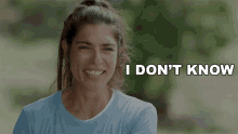 a woman in a blue shirt is smiling with the words i don 't know behind her
