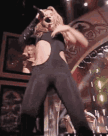 a woman singing into a microphone on a stage