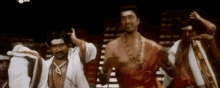 a group of men are dancing together on a stage in a dark room .