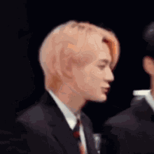 a man in a suit and tie is talking to another man .
