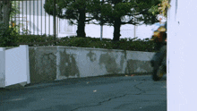 a person riding a motorcycle in front of a wall that says aa on it