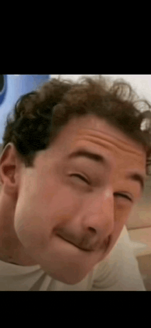 a man is making a funny face with his eyes closed