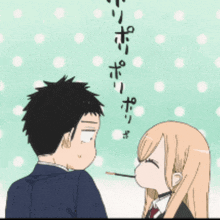 a man and a woman are standing next to each other and the girl is holding a stick in her mouth