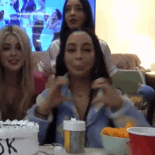 a group of women are sitting around a table with a cake that says 5k on it