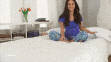 a woman is sitting on a bed with her legs crossed and a watermark that says getimages