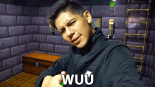 a man wearing a black jacket with the word wuu on the front
