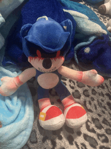 a stuffed toy of sonic the hedgehog is laying on a leopard print blanket