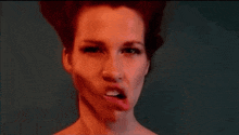 a woman with red hair is making a funny face with her mouth open