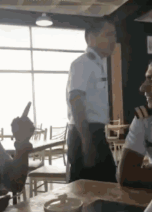 a man in a white uniform is standing in a restaurant