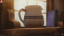 a pitcher sits on a shelf in front of a window with the words " the gif war " on the bottom