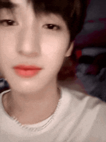 a close up of a person 's face with red lipstick and a white shirt .
