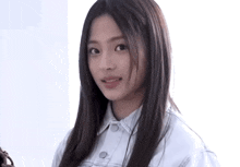 a woman with long hair is wearing a white jacket