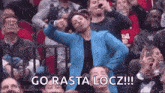 a woman in a blue jacket is dancing in a crowd of people .