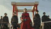 a man in a red coat is standing in front of a group of men
