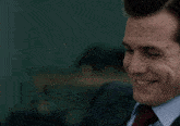 a man in a suit and tie is smiling for the camera .