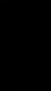 a close up of a person 's hand holding a candle in a dark room