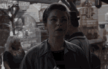 a woman stands in front of a display of bird cages with the caption #highcastle