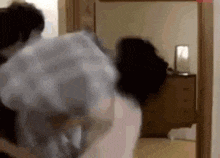 a person is standing in a room with a mirror and a dresser .