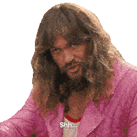 a man with long hair and a beard is wearing a pink jacket and saying shh