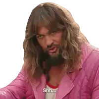 a man with long hair and a beard is wearing a pink jacket and saying shh