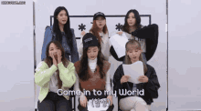 a group of girls are sitting in front of a white board with the words come in to my world on it