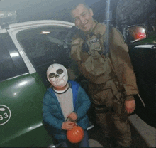 a police officer stands next to a boy wearing a skeleton mask and holding a pumpkin