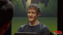a man is smiling in front of a screen that says dungeons & dragons