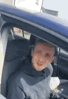 a man is sitting in the back seat of a car with his head out of the window .