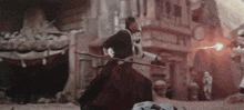 a man is holding a stick in his hand while a storm trooper shoots a lightning bolt .