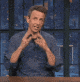 a man in a blue shirt is holding a piece of paper in his hand