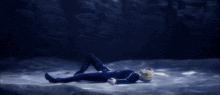 a person with blonde hair is laying on the ground with their head up
