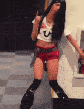 a woman wearing a crop top with a letter u on it