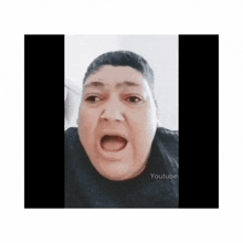 a man is making a funny face with his mouth open and his eyes closed .