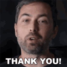 a man with a beard is giving a thank you gesture .