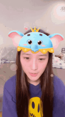 a girl wearing a blue elephant mask with a crown