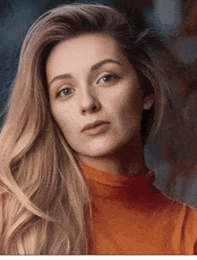 a woman with long blonde hair is wearing a red shirt